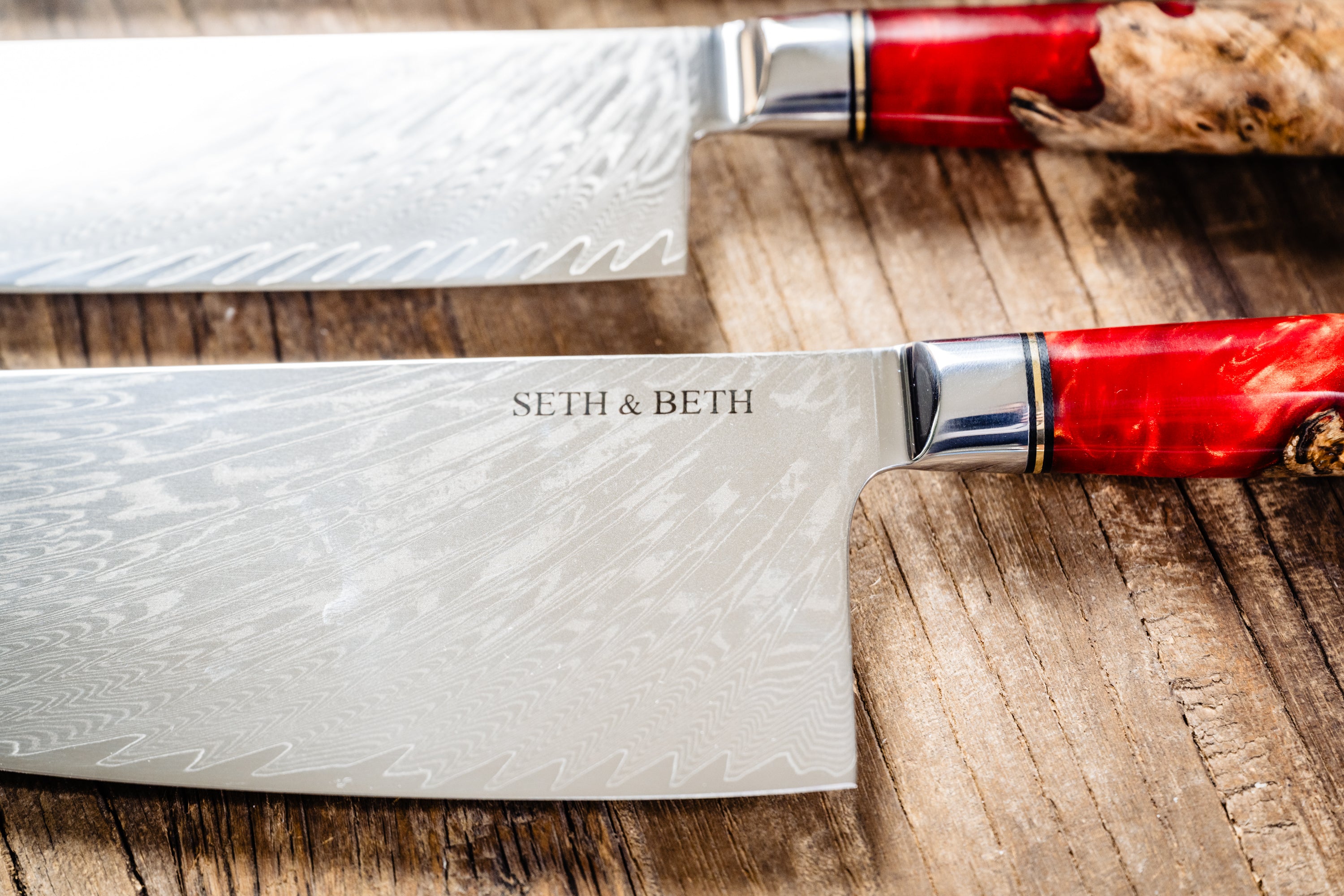 Red burl handle engraved Damascus knife set displayed on wooden surface — Tidal Collection